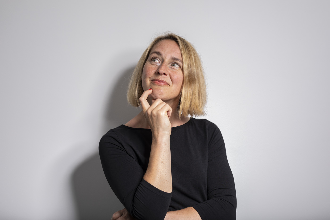 Yvonne Schneider in Gedanken vor heller Wand