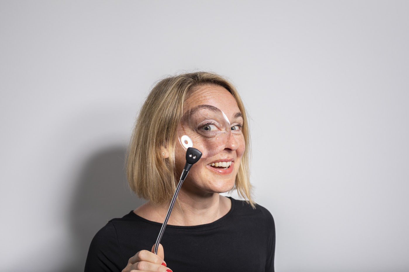 Yvonne Schneider schaut lachend durch eine Lupe